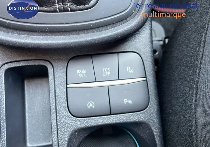 Gros plan sur les commandes noires du tableau de bord du Ford Puma 2023, avec boutons de sécurité et assistances visibles.