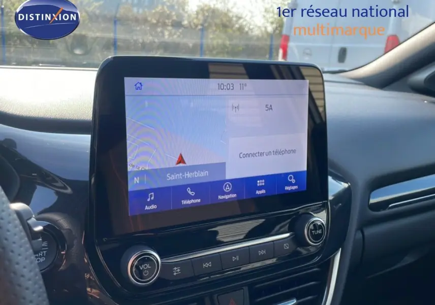 Vue intérieure centrée sur l'écran tactile du tableau de bord du Ford Puma noir agate métal, avec navigation affichée.