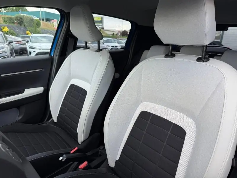 Vue intérieure rapprochée des sièges avant bicolores noir et clair de la Citroën C3 2025 avec toit Bright Blue visible à l'arrière.