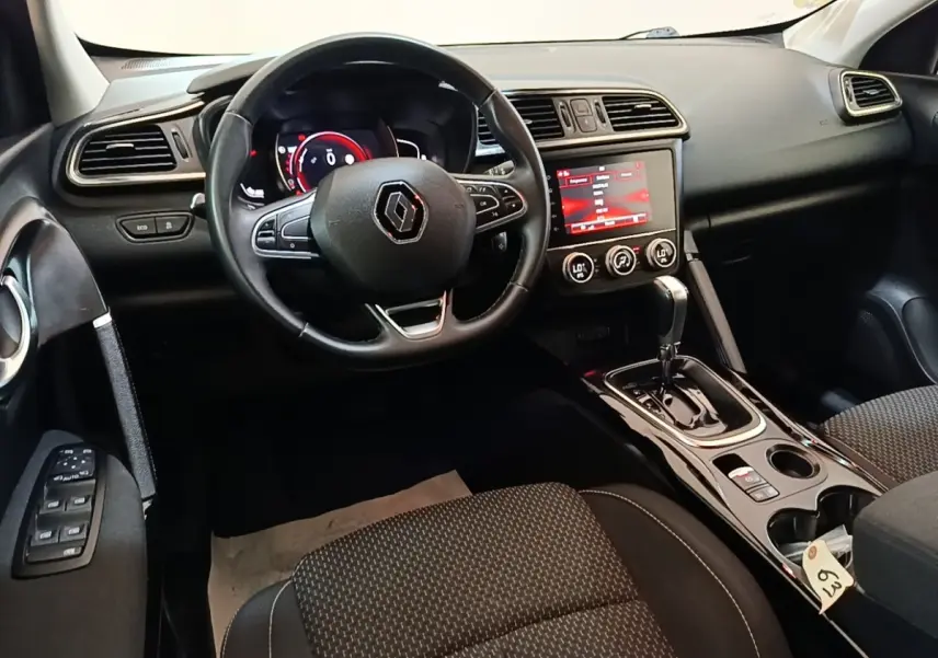Vue intérieure du poste de conduite du Renault Kadjar 2021, avec volant multifonctions et écran tactile central allumé.