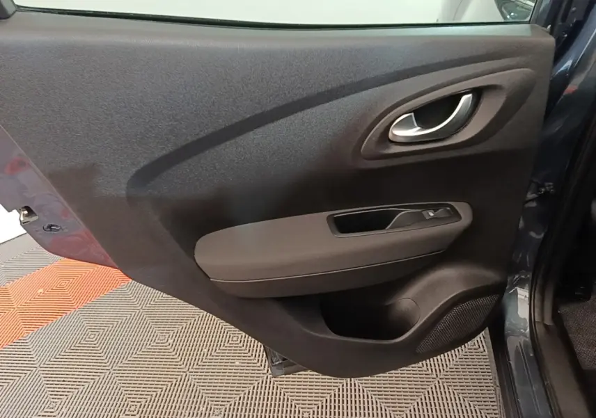Vue rapprochée de la porte arrière droite gris foncé du Renault Kadjar 2021 avec poignée intérieure et commande de vitre.