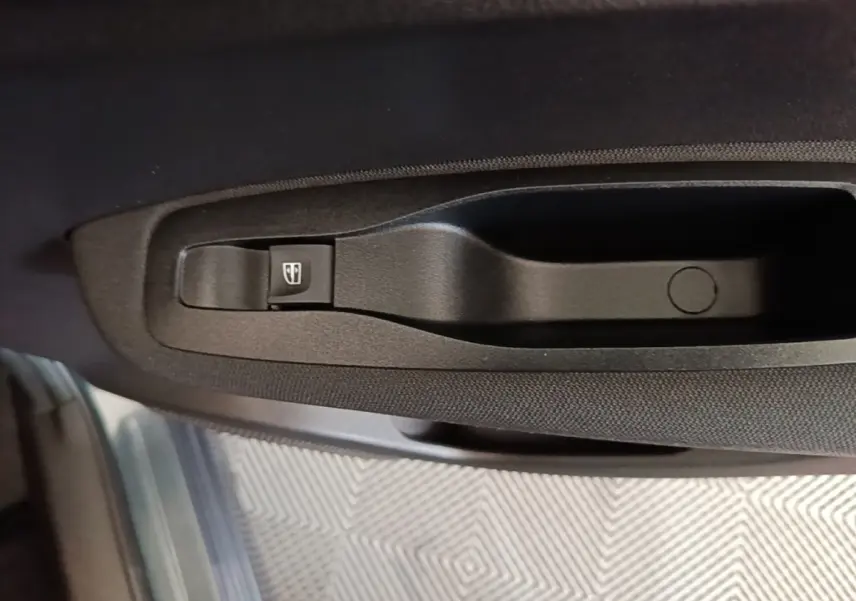 Gros plan sur la commande de lève-vitre côté conducteur du Renault Kadjar gris foncé, intérieur tissu noir.