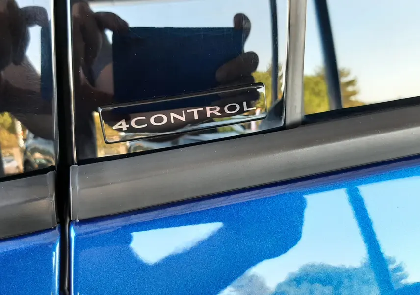 Gros plan sur l’inscription 4CONTROL sur la portière côté gauche d’un Renault Austral bleu Iron.