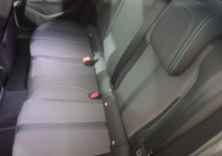 Vue rapprochée de la banquette arrière grise de la Peugeot 308 PHEV 180 E-EAT8 Allure avec ceintures et appuie-tête.