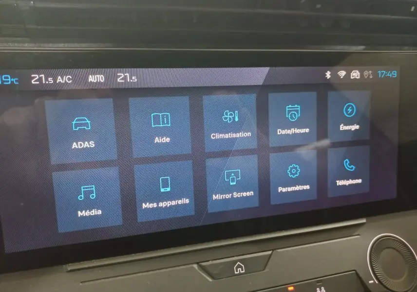 Écran tactile central de la Peugeot 308 PHEV 2025 affichant les menus climatisation, aide et énergie.