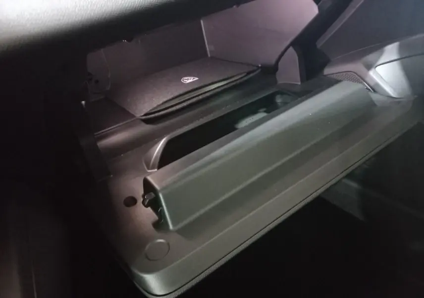 Vue rapprochée de la boîte à gants ouverte du Peugeot 308 PHEV 180 E-EAT8 Allure, intérieur noir.