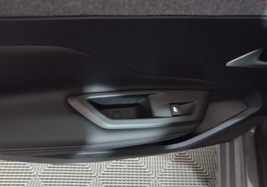 Poignée intérieure de porte côté gauche en plastique noir de la Peugeot 308 PHEV 180 E-EAT8 Allure 2025.