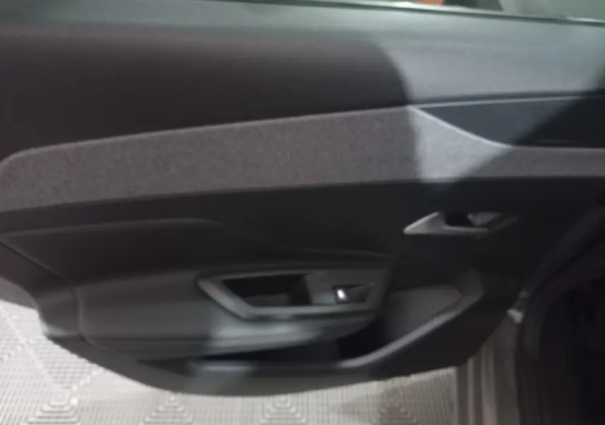Vue intérieure de la porte côté droit de la Peugeot 308 PHEV 180 E-EAT8 Allure gris foncé, avec poignée intégrée.