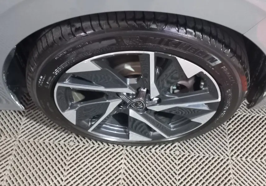 Gros plan sur la roue avant droite de la Peugeot 308 PHEV 180 E-EAT8 Allure gris foncé, jante alliage stylisée.