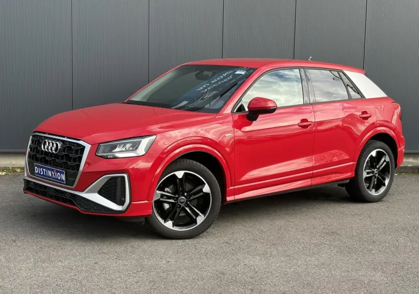 Audi Q2 30 TFSI S-Line rouge progressif vue 3/4 avant droit avec toit blanc et jantes alliage noir poli.