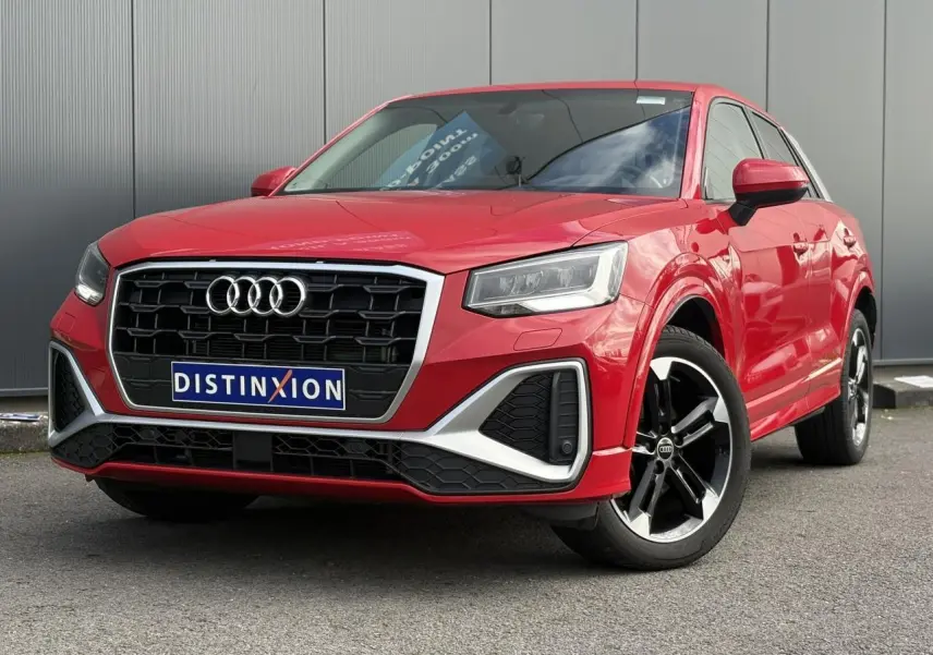 Audi Q2 30 TFSI S-Line rouge Progressif en 3/4 avant droit, avec calandre noire et jantes alliage 5 branches doubles.