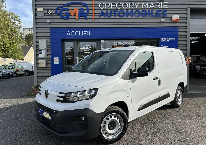 Peugeot Partner Fourgon blanc vu en 3/4 avant droit, avec rétroviseurs noirs et plancher bois visible à l'intérieur.