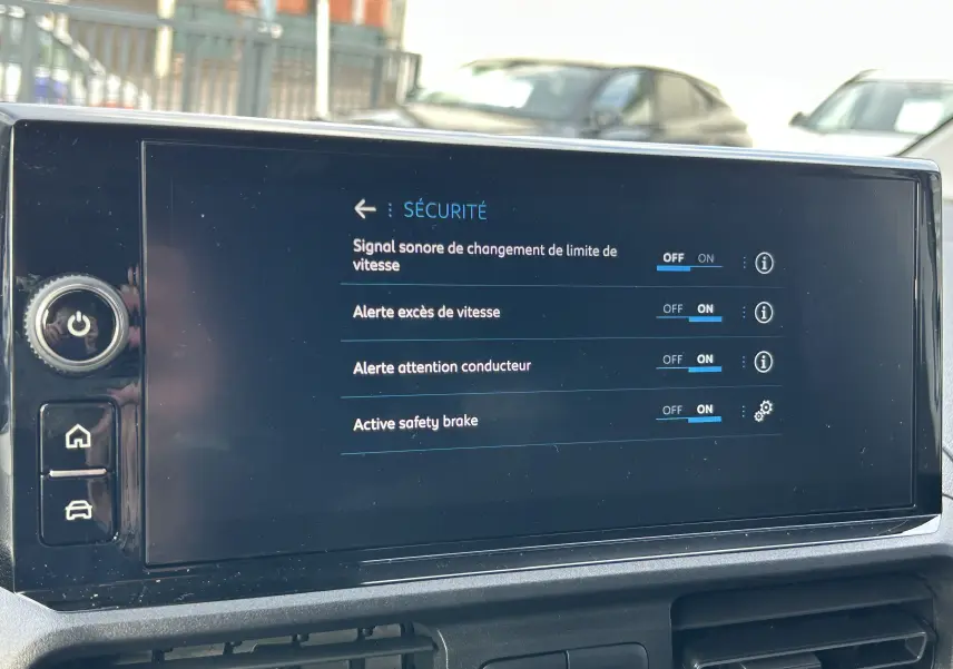 Écran tactile intérieur du Peugeot Partner Fourgon blanc affichant les réglages de sécurité du véhicule.