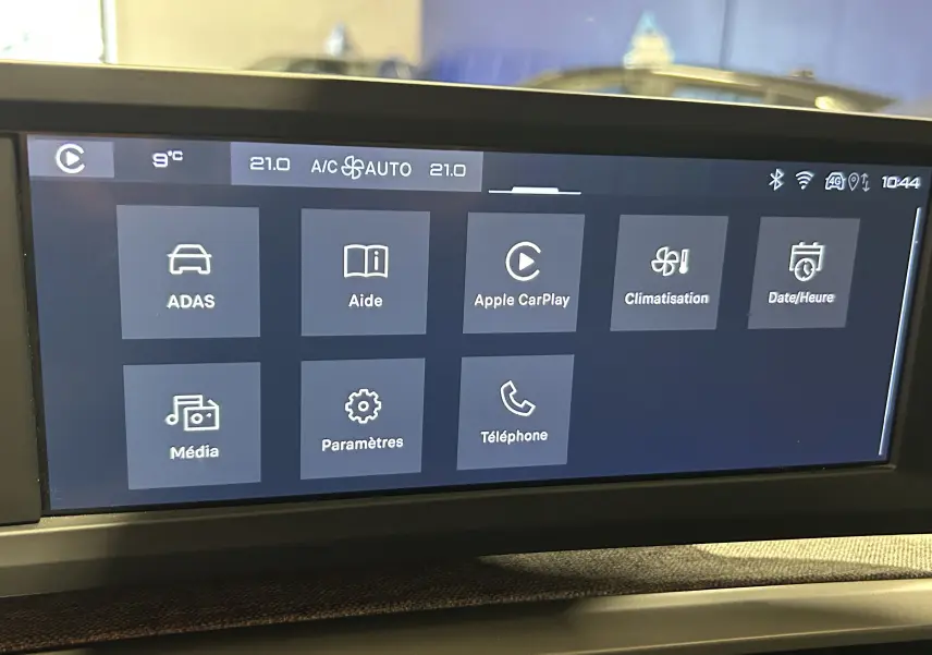Écran tactile central du tableau de bord du Peugeot 5008 III Hybrid avec interface multimédia et climatisation affichée.