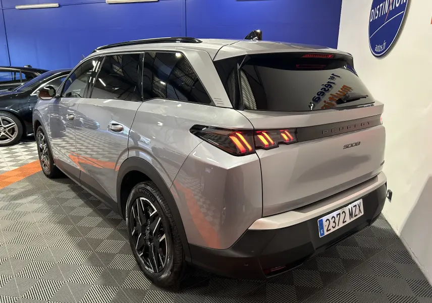 Vue 3/4 arrière droite du Peugeot 5008 gris Artense avec feux arrière LED et jantes noires en concession.