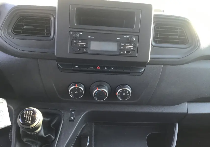 Vue rapprochée du tableau de bord noir du Renault Master 2022 avec commandes climatisation et levier de vitesses manuel.