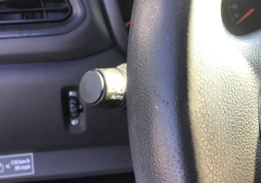 Gros plan sur le volant noir et la commande d'éclairage à gauche du tableau de bord du Renault Master blanc 2022.