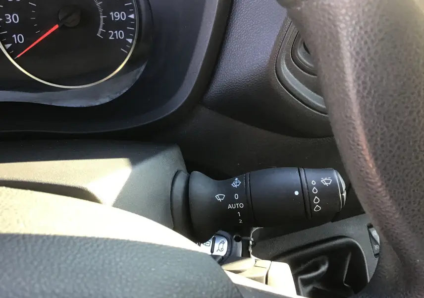 Gros plan sur la manette d’essuie-glace noire côté droit du tableau de bord d’un Renault Master blanc de 2022.