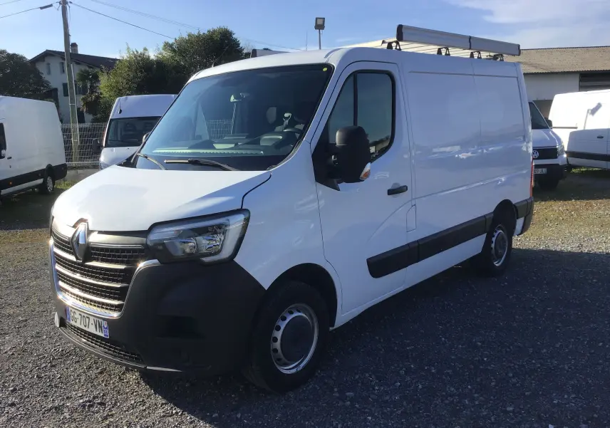 Vue 3/4 avant droite d’un Renault Master blanc 2022 avec galerie de toit et rétroviseurs noirs sur un parking.