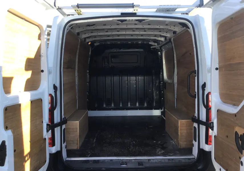 Vue arrière ouverte du Renault Master blanc 2022, montrant l'intérieur utilitaire avec habillage bois sur les parois et portes.