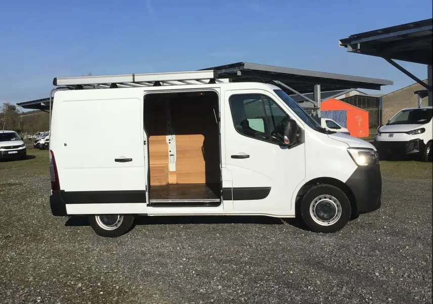 Vue de profil droit du Renault Master blanc 2022 avec porte latérale ouverte et galerie sur le toit.