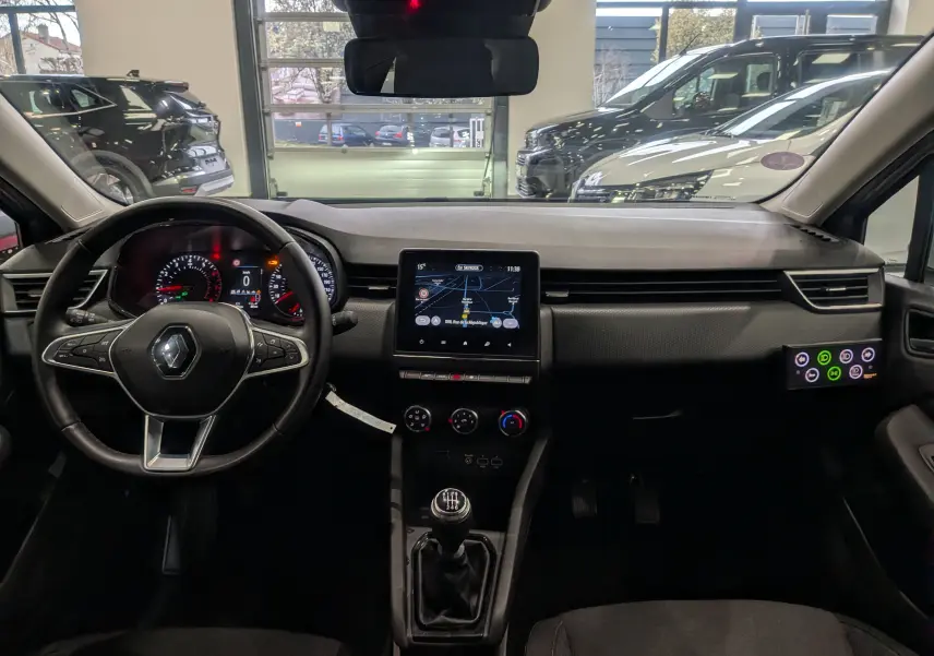 Vue intérieure avant de la Renault Clio V TCe 90 Auto-école 2021, tableau de bord noir avec écran tactile et levier de vitesses manuel.