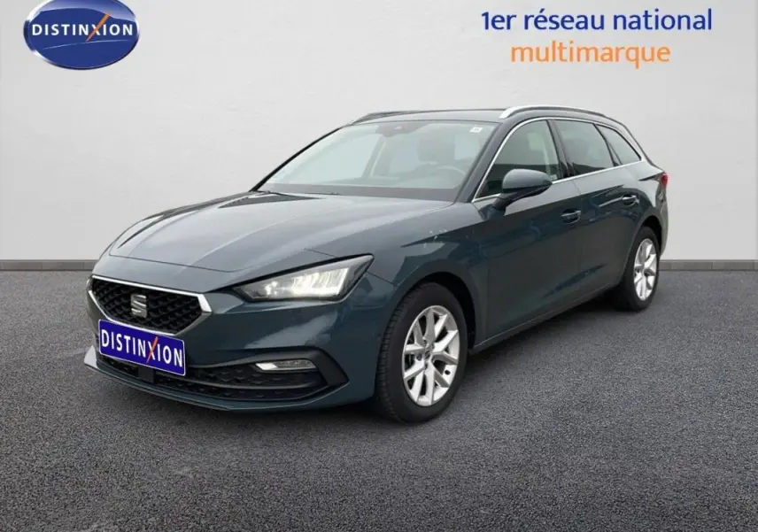 SEAT Leon ST bleu 3/4 avant droit avec barres de toit et jantes aluminium sur fond neutre.