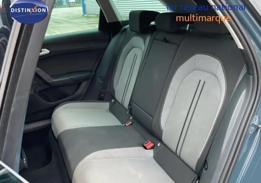 Vue intérieure montrant la banquette arrière bicolore gris clair et noir du SEAT Leon ST bleu, porte arrière ouverte côté droit.