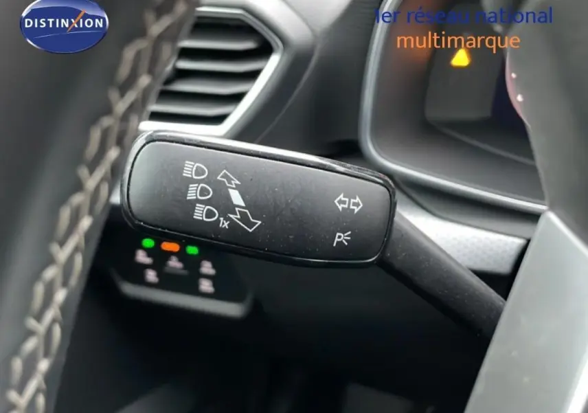 Gros plan sur la commande des feux et clignotants à gauche du volant dans l’habitacle du SEAT Leon ST bleu.