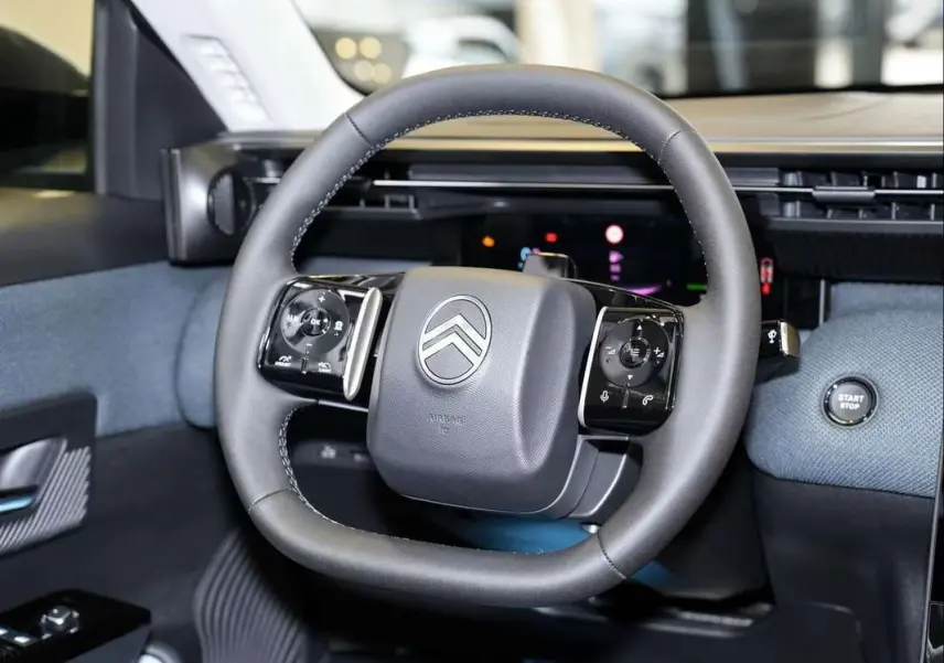 Vue rapprochée du volant cuir multifonctions de la Citroën C5 Aircross New Hybrid 2026 avec tableau de bord numérique.