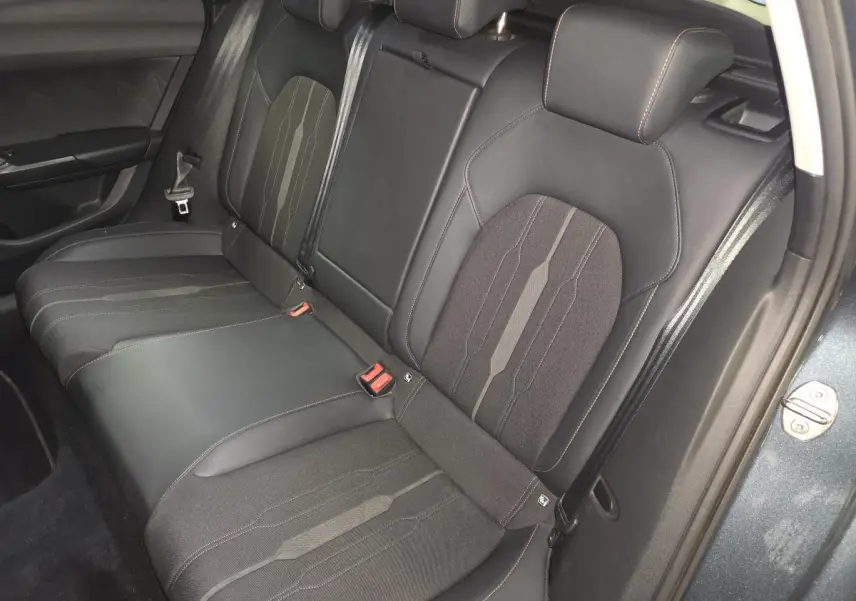Vue du siège arrière droit de la CUPRA Leon Sportstourer 2024, avec sellerie noire en similicuir et tissu, surpiqûres Copper visibles.