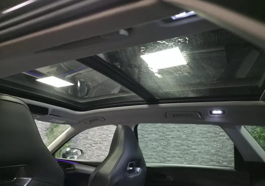 Vue intérieure du toit ouvrant panoramique du CUPRA Leon Sportstourer gris avec sièges baquets noirs.
