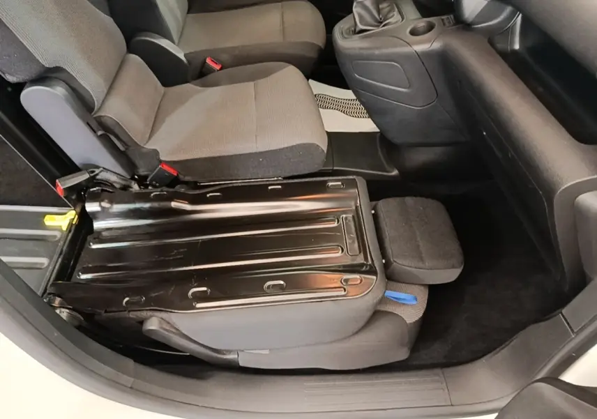 Vue intérieure côté droit du siège avant relevé du Citroën Berlingo blanc, montrant la structure métallique du siège.