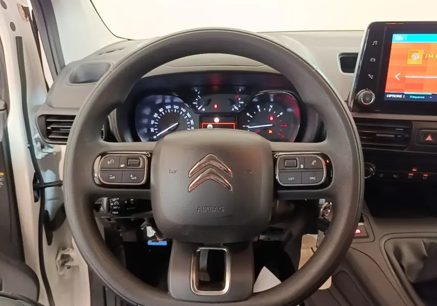 Vue centrée sur le volant noir de la Citroën Berlingo blanc 2020 avec tableau de bord et écran tactile visible.