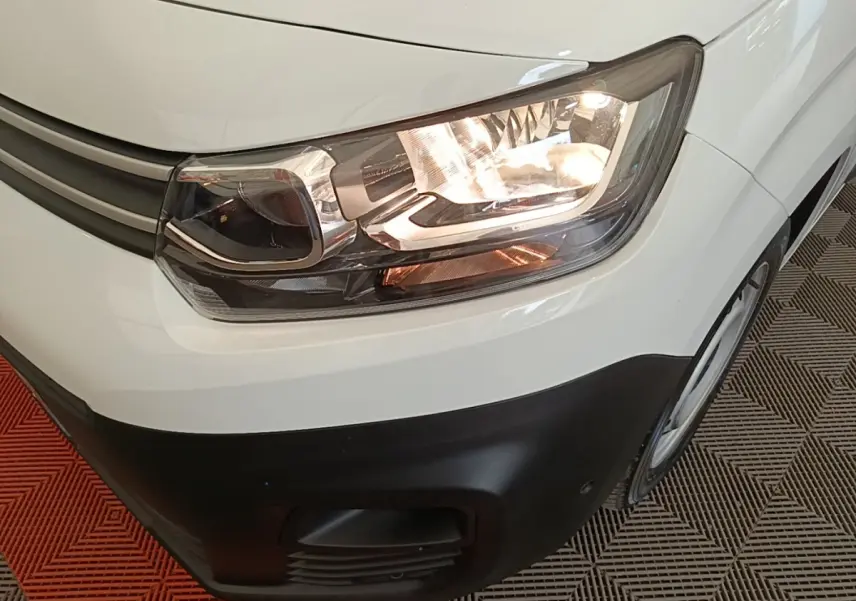 Gros plan sur l'avant droit blanc du Citroën Berlingo 2020 avec phare allumé et pare-chocs noir.