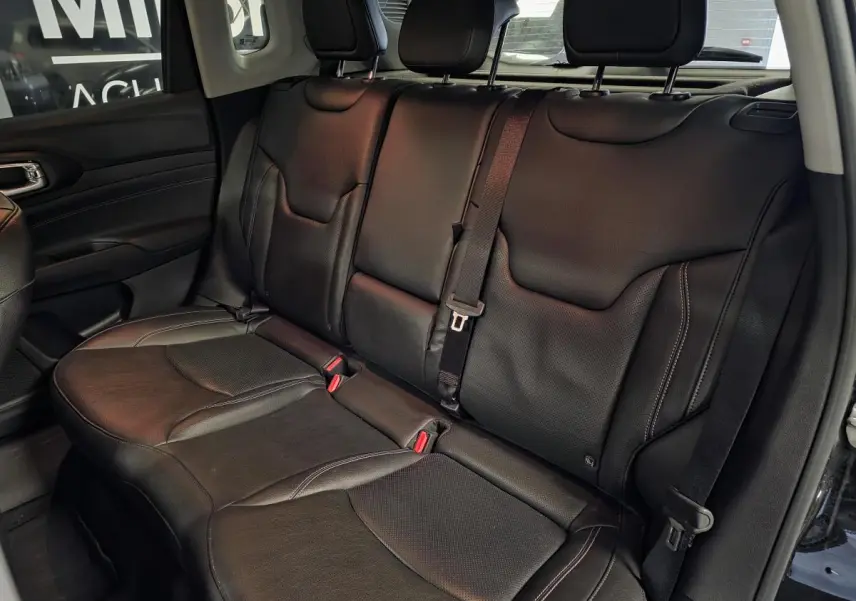 Vue latérale des sièges arrière en cuir noir du Jeep Compass 2022 avec ceinture de sécurité centrale visible