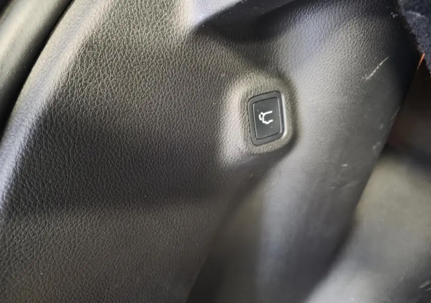 Bouton de déverrouillage du hayon sur panneau intérieur noir du coffre du Jeep Compass hybride rechargeable 2022.