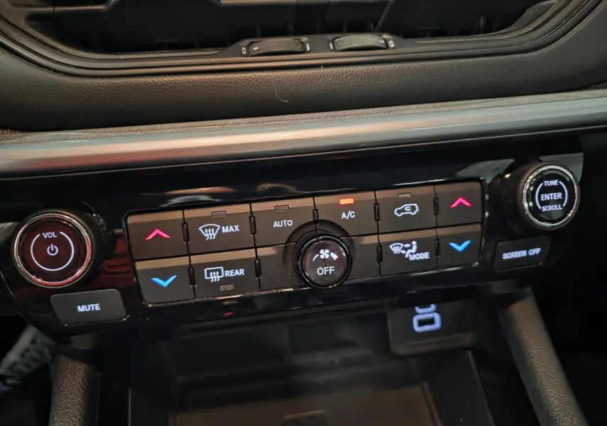 Panneau de commande de climatisation et audio du Jeep Compass 2022 noir, avec boutons rétroéclairés et molette centrale.