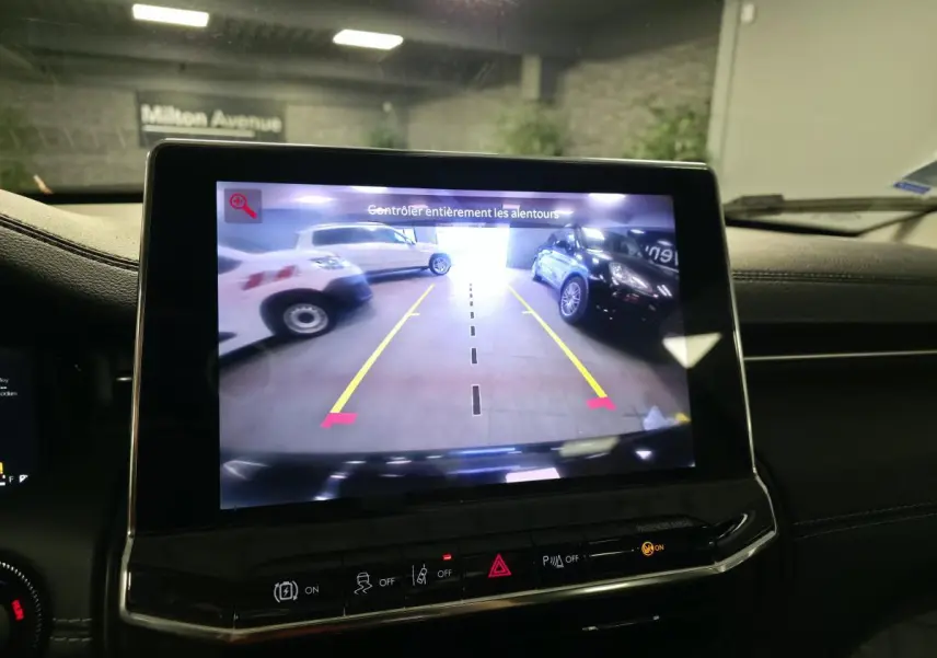 Écran tactile intérieur affichant la caméra de recul du Jeep Compass noir, vue arrière avec lignes de guidage jaunes.