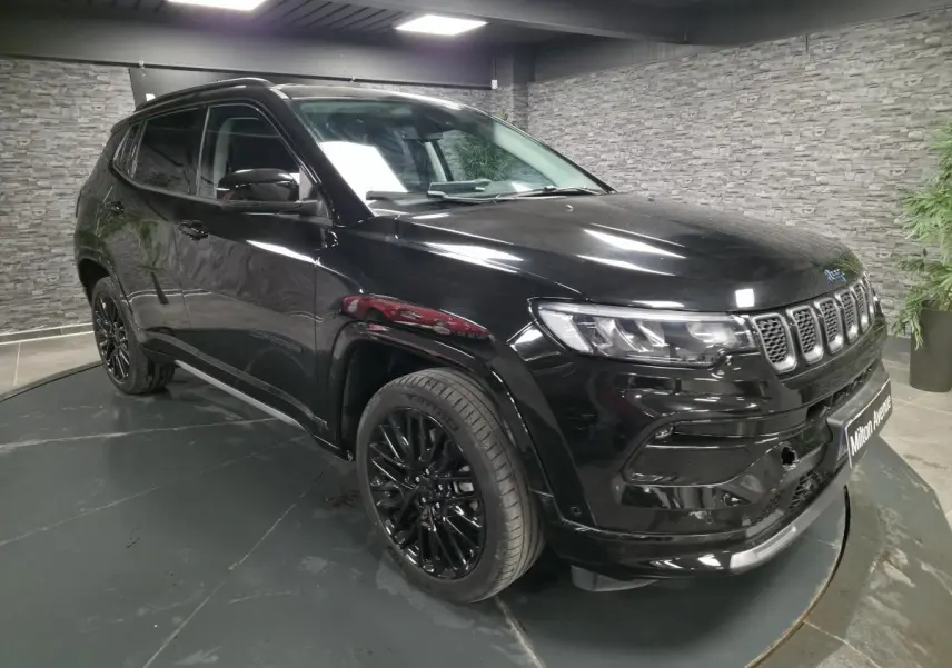 Jeep Compass noir en 3/4 avant droit, avec jantes alliage noires et toit noir dans un showroom intérieur.