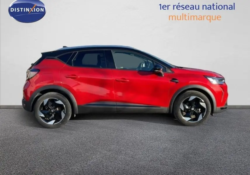 Profil côté gauche d'un Renault Captur rouge 2025 avec jantes aluminium noires et barres de toit visibles.