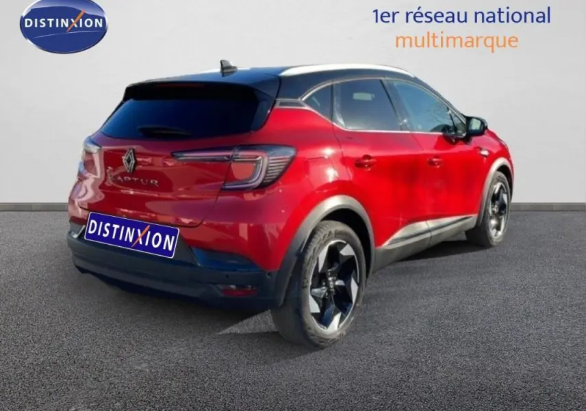 Vue 3/4 arrière droite d'un Renault Captur rouge avec toit noir et jantes aluminium noires.