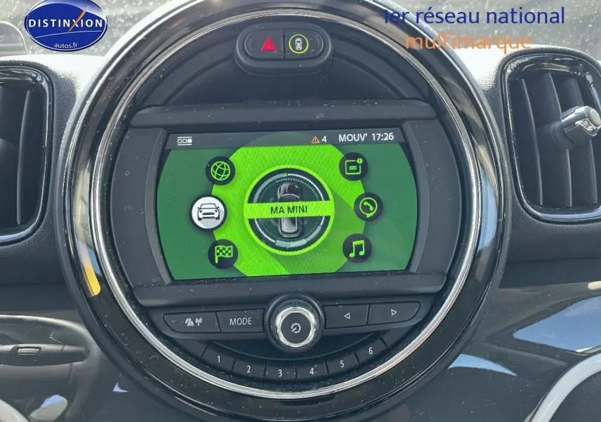 Vue rapprochée du tableau de bord de la MINI Countryman Moonwalk Grey, écran central rond avec interface verte et commandes intégrées.