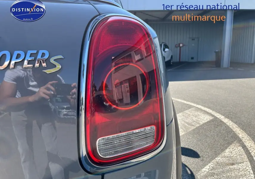 Gros plan sur le feu arrière droit d’une MINI Countryman Cooper S Moonwalk Grey avec reflet du photographe.
