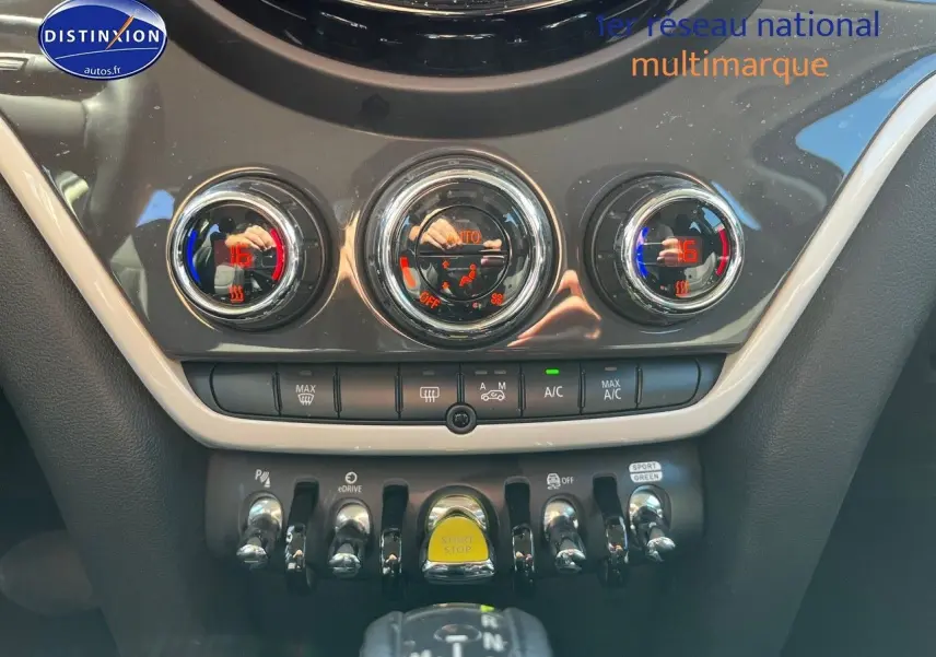 Vue rapprochée de la console centrale du MINI Countryman Moonwalk Grey, avec commandes clim et bouton Start/Stop jaune.