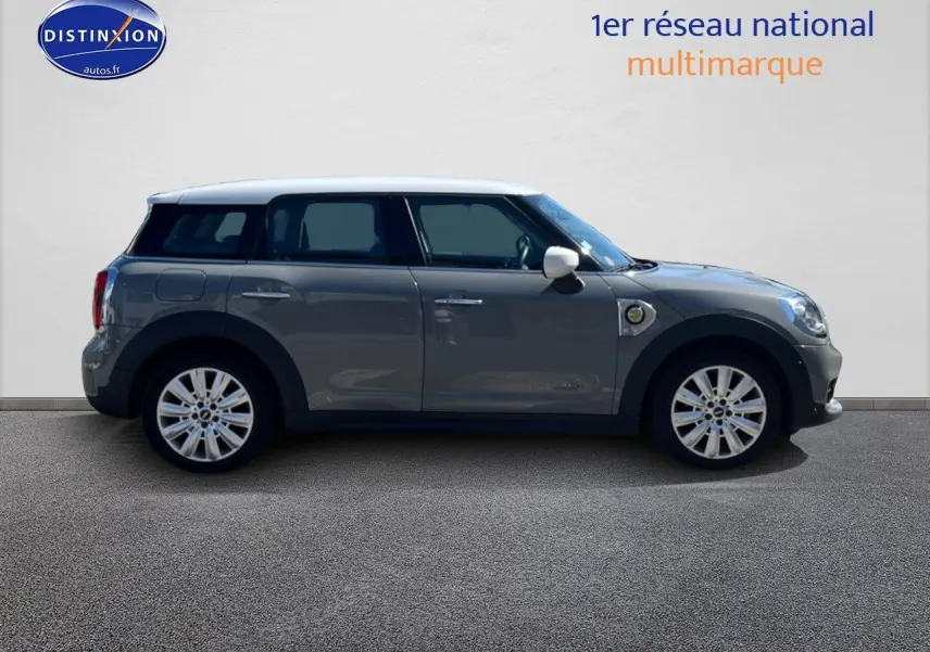 Profil droit d'une MINI Countryman hybride rechargeable Moonwalk Grey avec toit et rétroviseurs blancs, jantes alu 18 pouces.