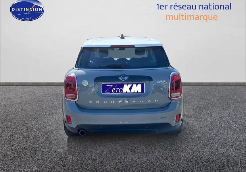 Vue arrière d'une MINI Countryman Cooper SE Moonwalk Grey avec toit blanc sur fond neutre.