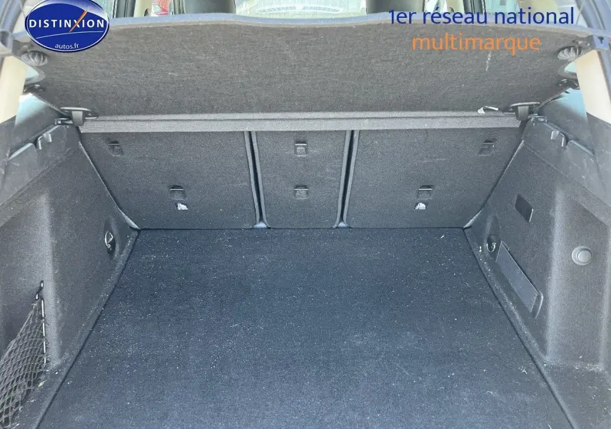 Coffre ouvert vu de face d’un MINI Countryman hybride gris Moonwalk avec cache-bagages relevé.