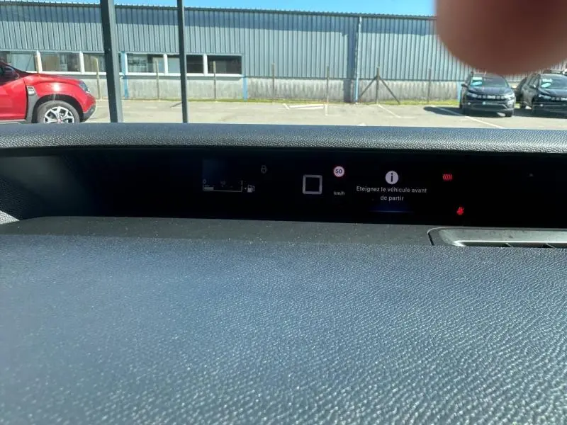 Vue rapprochée du tableau de bord numérique de la Citroën C3 noire 2025 affichant un message d'alerte avant départ.