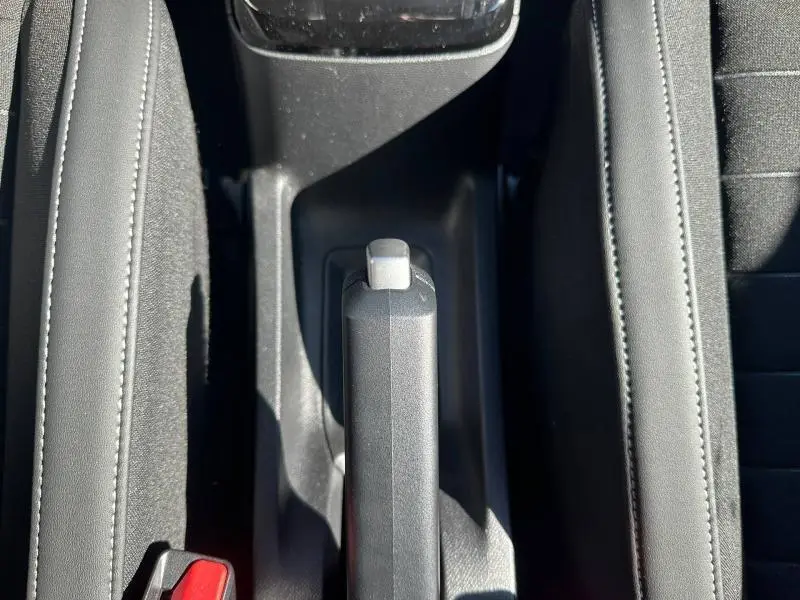 Vue plongeante sur le frein à main manuel noir entre les sièges avant du Citroën C3 2025, version 1.2 Turbo 100ch MAX.